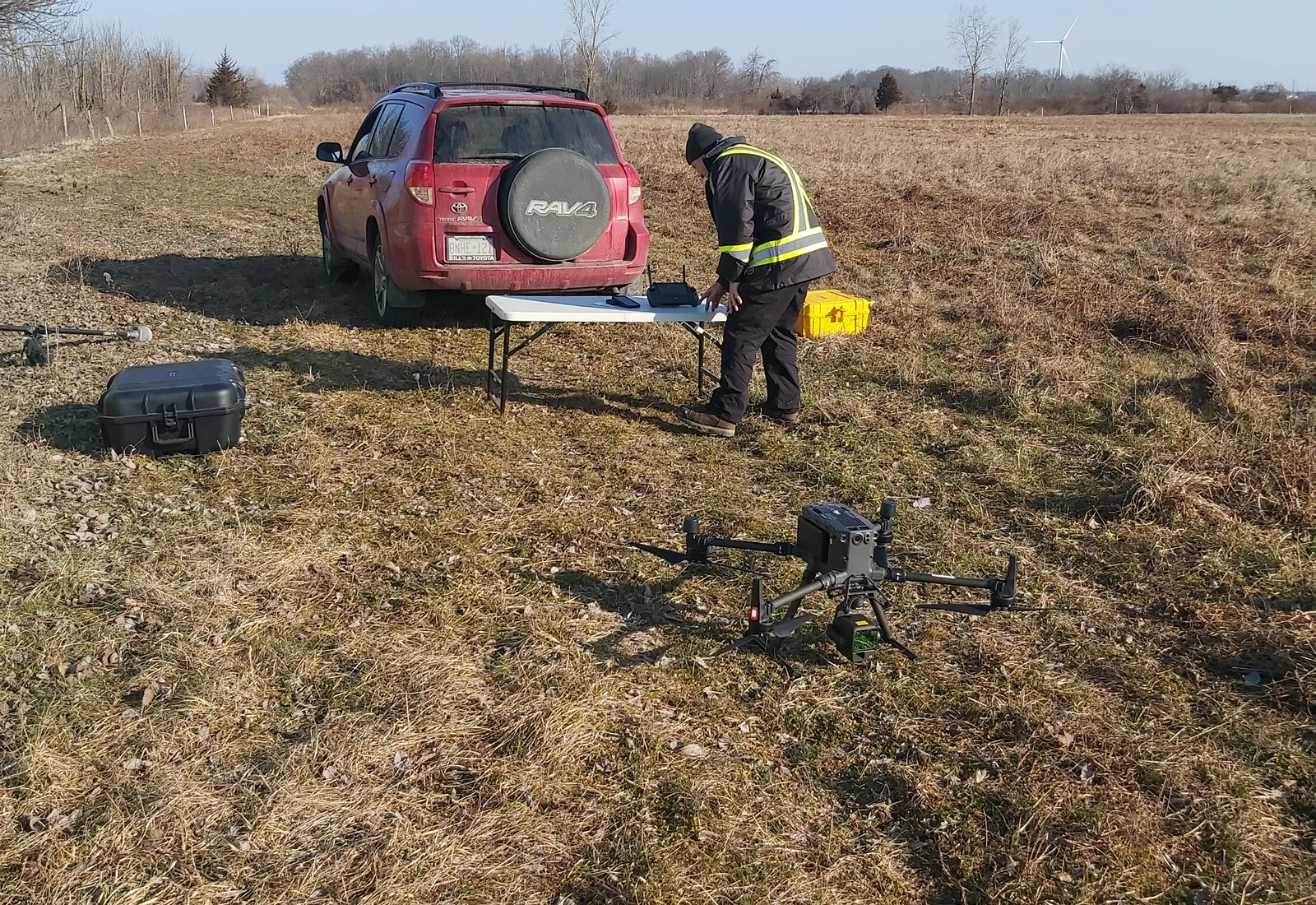 Surveyor preparing aerial survey equipment at a rural site